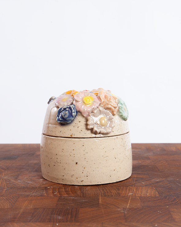 Håndlavet keramikskrin i lyst ler med lavapletter med låg dækket af farverige blomster i relief.