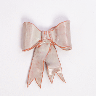Keramisk væghængt sløjfe i rosa og hvid, håndlavet, ca. 12 × 15 cm.